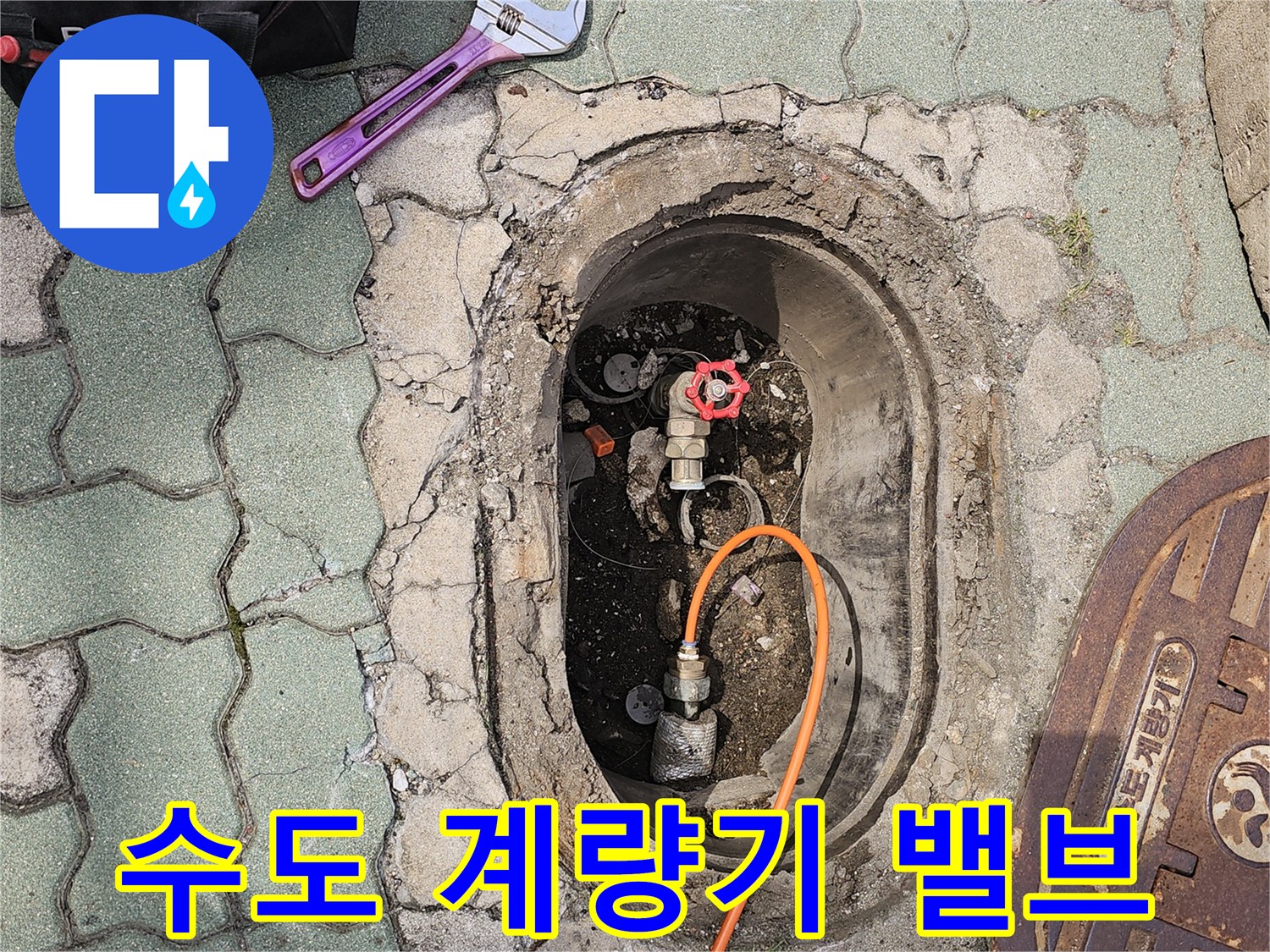 계량기함 내부의 붉은색 밸브와 주황색 호스 연결 모습