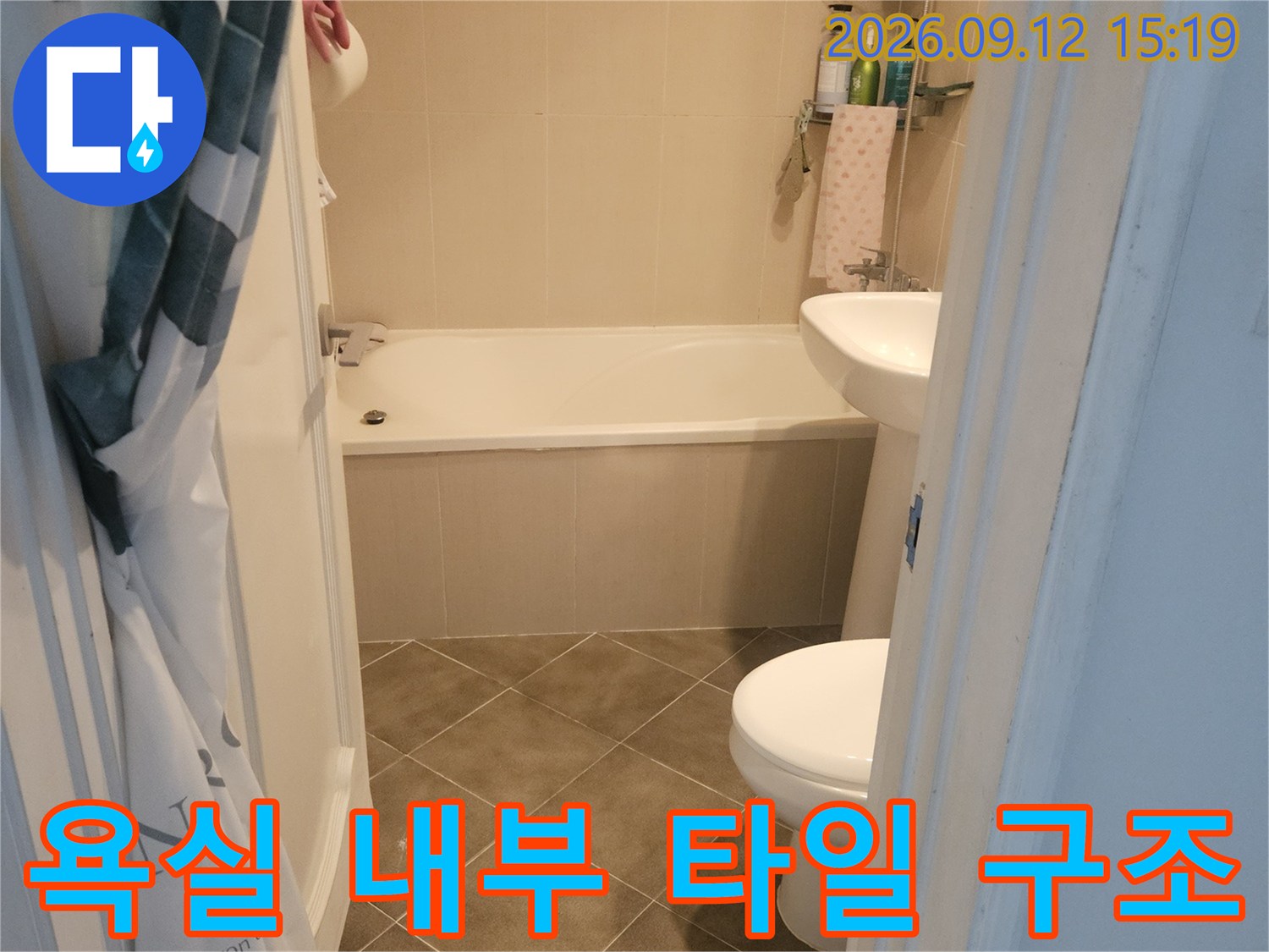 갈색 타일로 시공된 화장실 바닥과 욕조 주변 모습입니다.