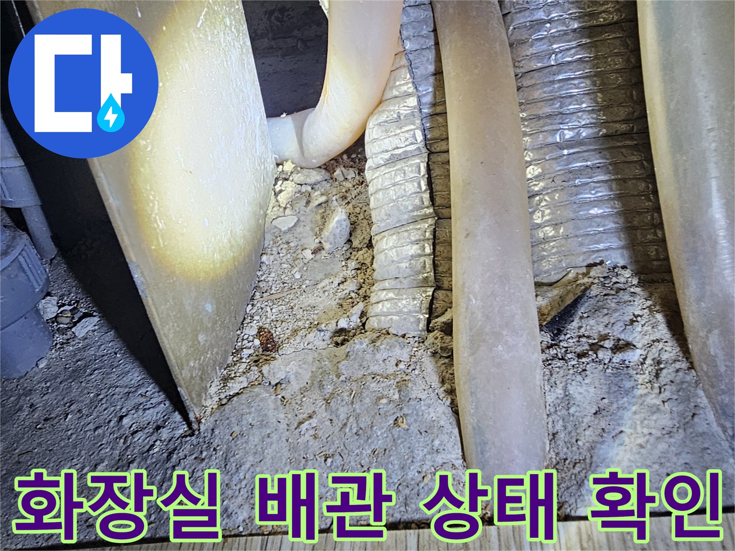 화장실 인접 벽면 내부의 노출된 배관과 주변 습기 상태를 보여주는 사진입니다.