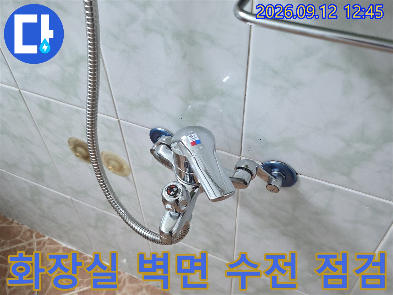 벽면에 고정된 은색 수도꼭지와 샤워 호스 연결부 상세 모습