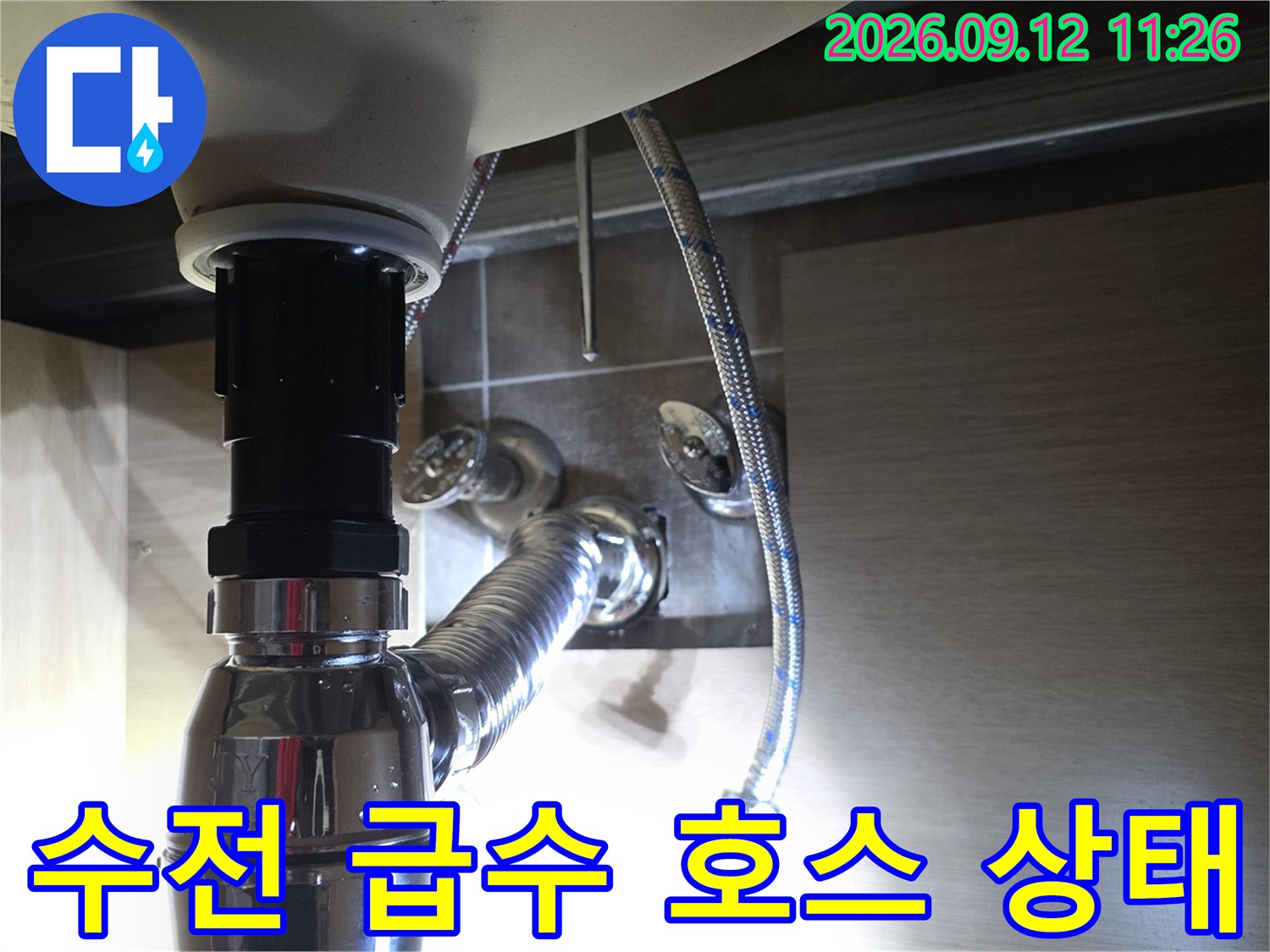 세면대 수전 뒤쪽으로 연결된 은색 급수 호스 상세 모습
