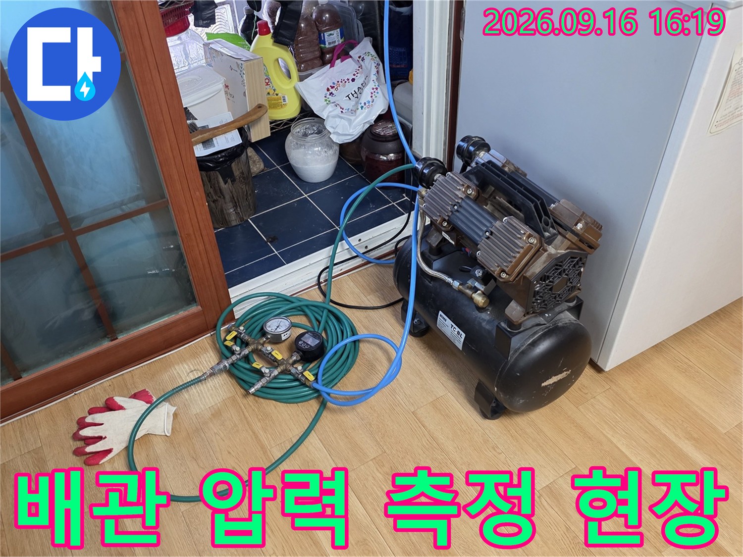 누수 탐지를 위해 배관에 연결된 압력 게이지와 에어 호스입니다.
