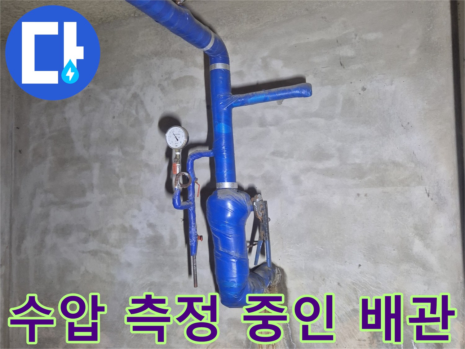 압력계가 연결된 푸른색 보온 배관의 지하 매립 구간