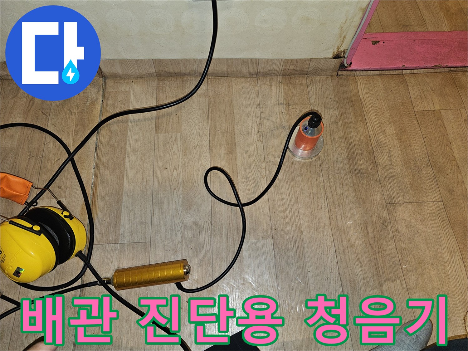 바닥면을 따라 연결된 배관 검사용 청음식 탐지 도구와 호스입니다.