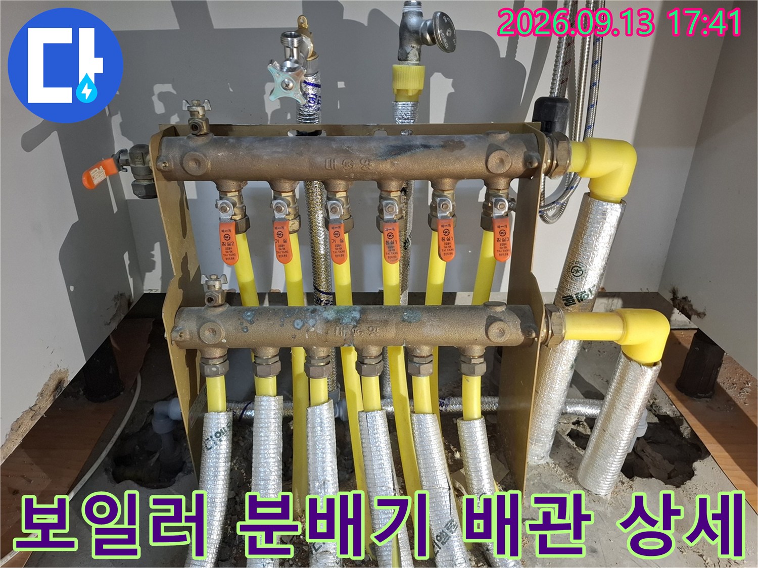 싱크대 하단 보일러 분배기와 노란색 난방 배관 사진