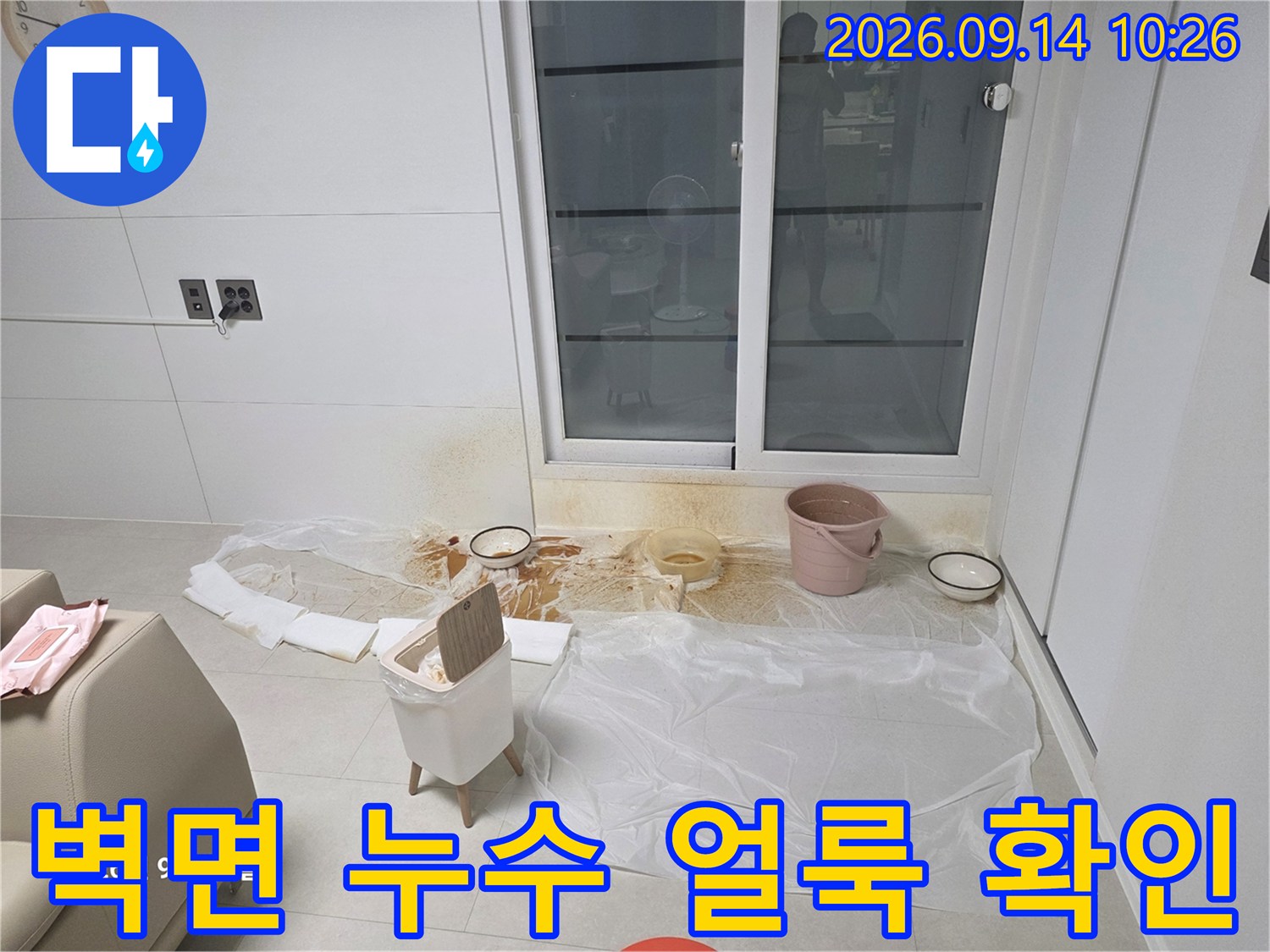 창문 아래쪽 벽면에 생긴 누수 흔적과 보양된 바닥입니다.