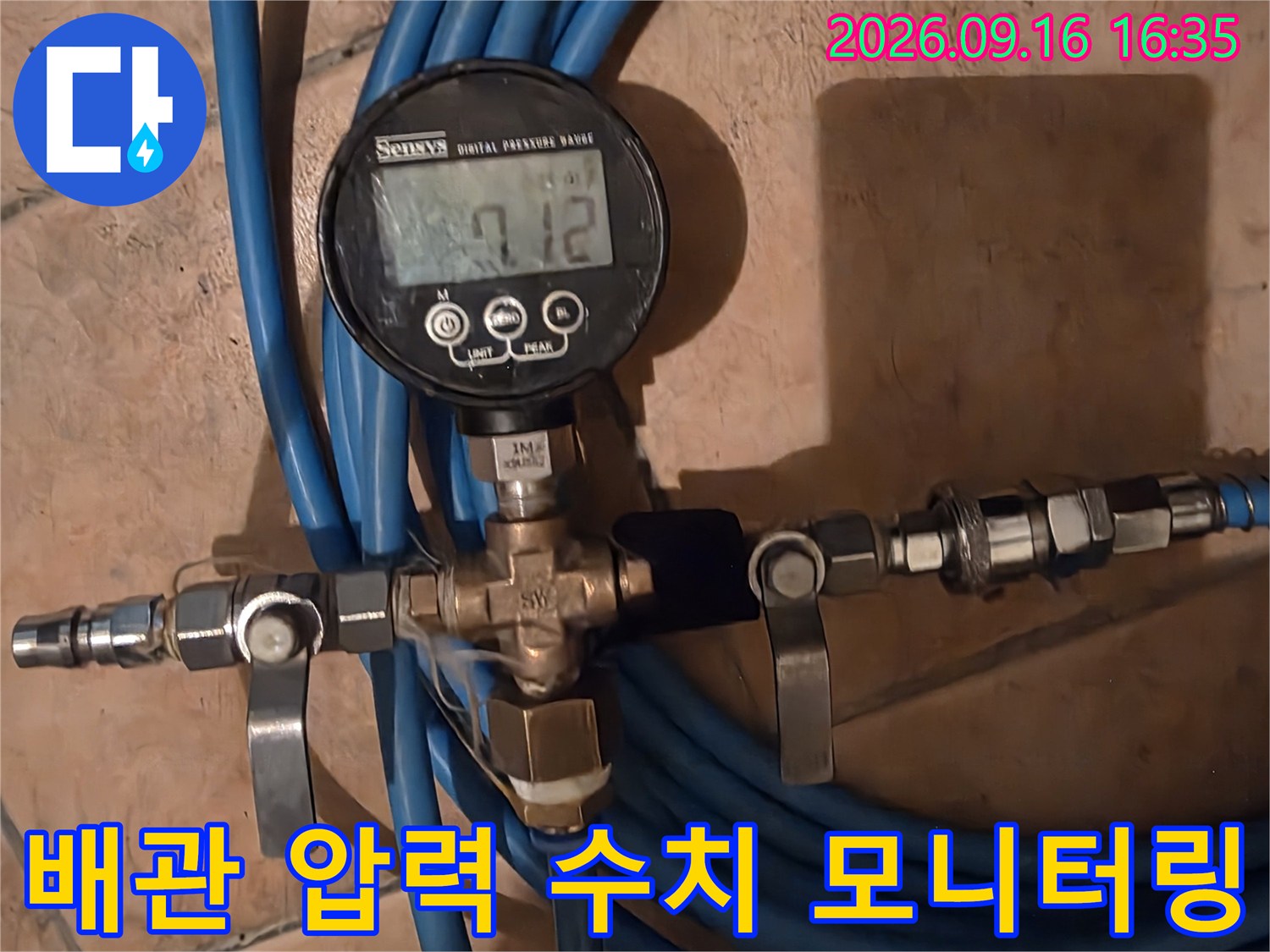 디지털 장비를 사용하여 배관의 수압을 측정하고 있는 모습입니다.