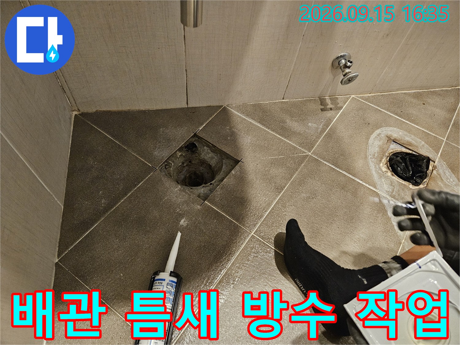 배수구 주변의 타일 틈을 실란트로 메우는 공사 모습입니다.