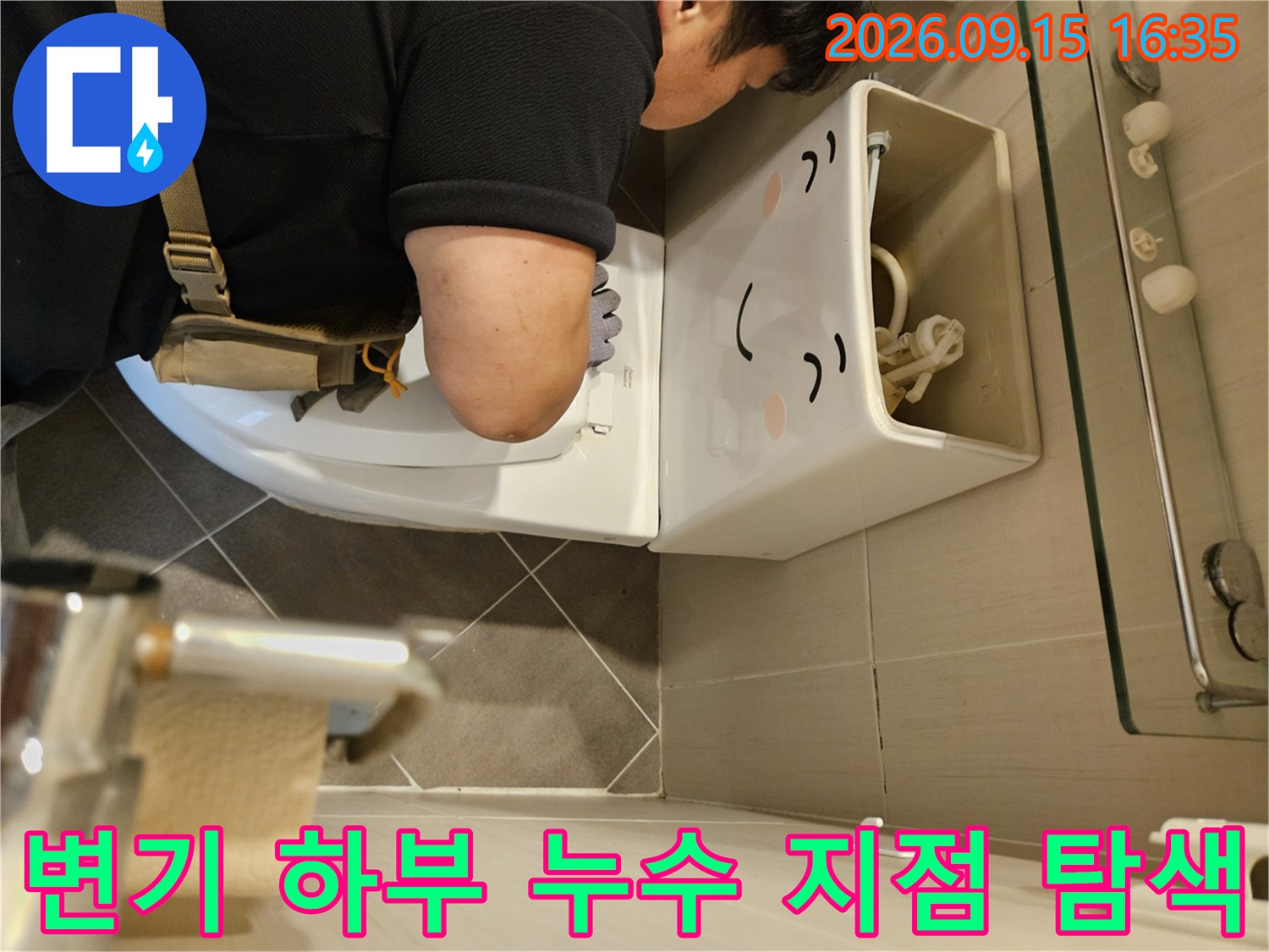 변기 아래쪽의 좁은 틈새를 통해 배관 상태를 확인하는 모습입니다.