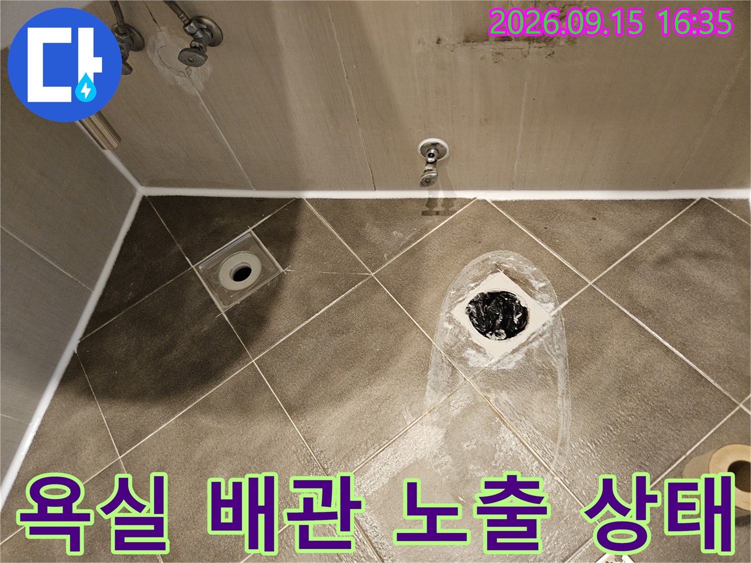 타일을-걷어낸 화장실 바닥의 배수구 배관과 주변 정리 모습