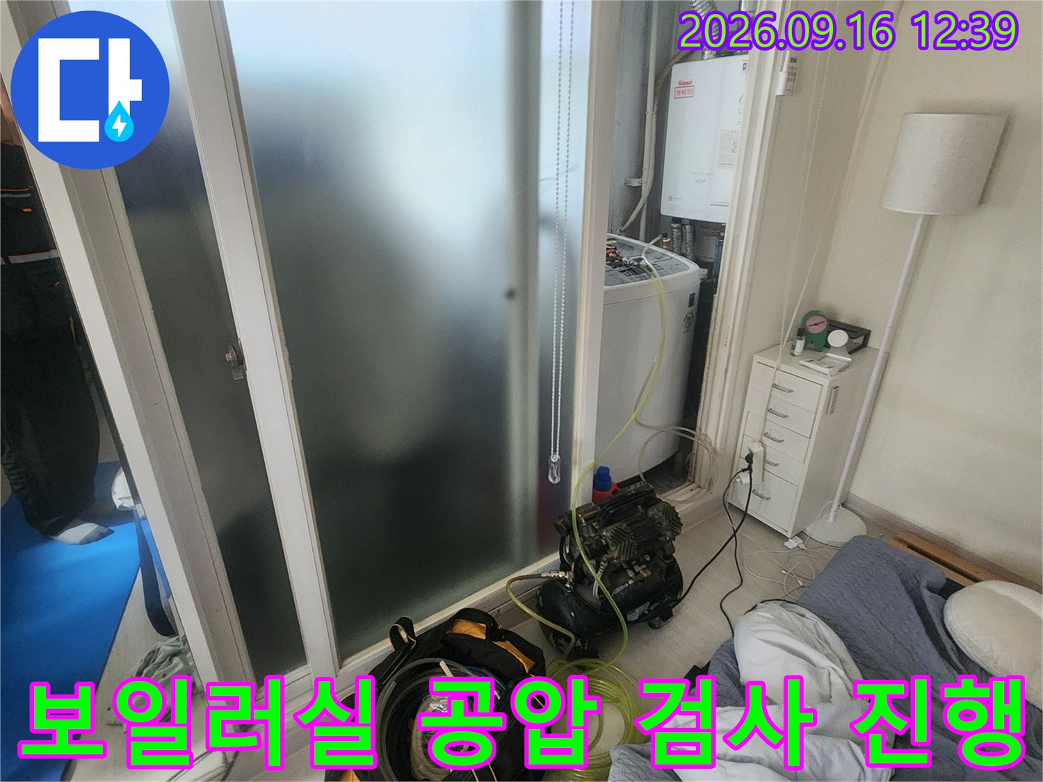 보일러실 내부에서 배관 압력 손실을 확인하기 위해 공압 검사 장비를 연결한 모습입니다.