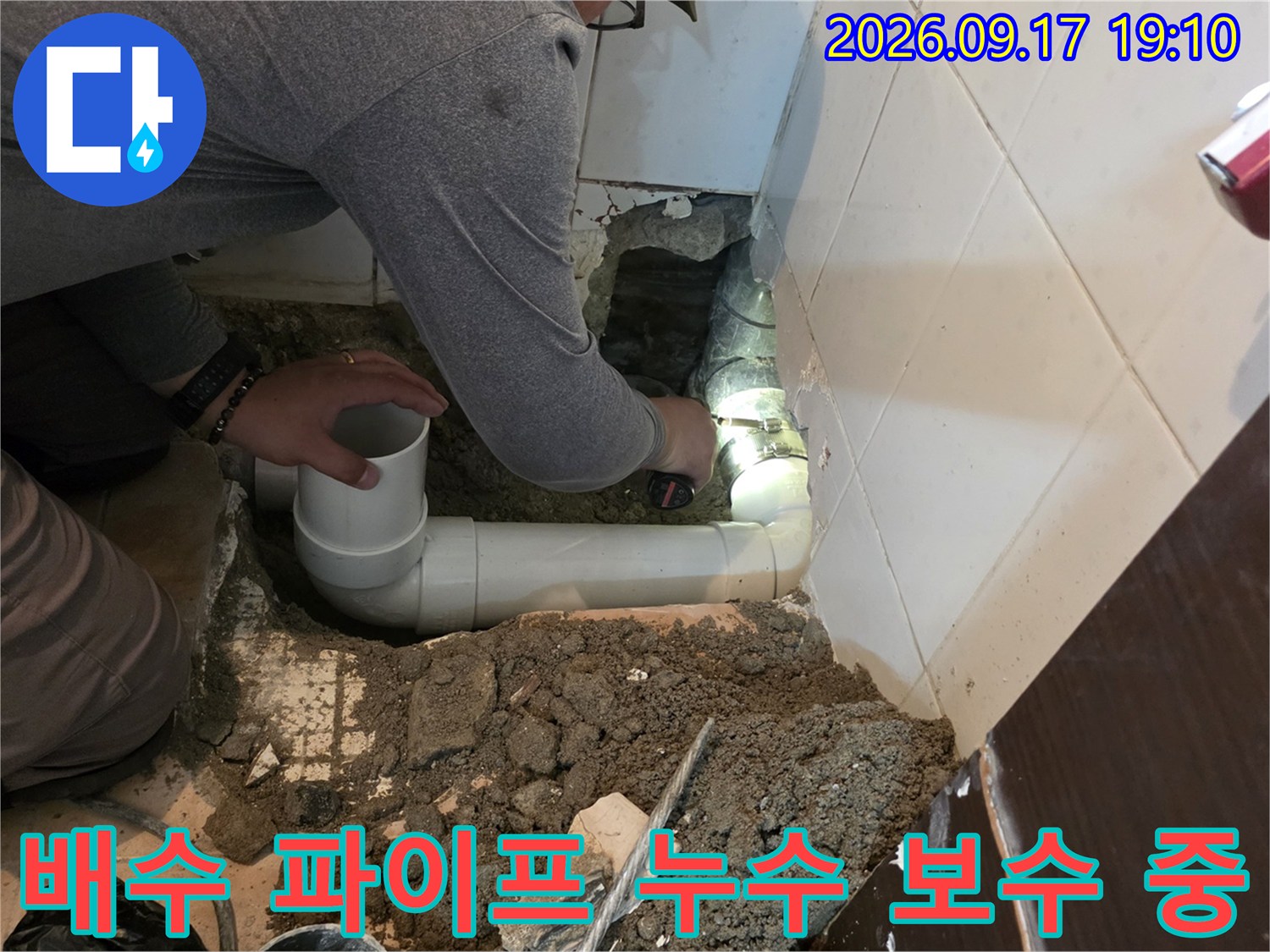 새로 연결된 흰색 PVC 배수관과 굴착된 바닥의 모습입니다.