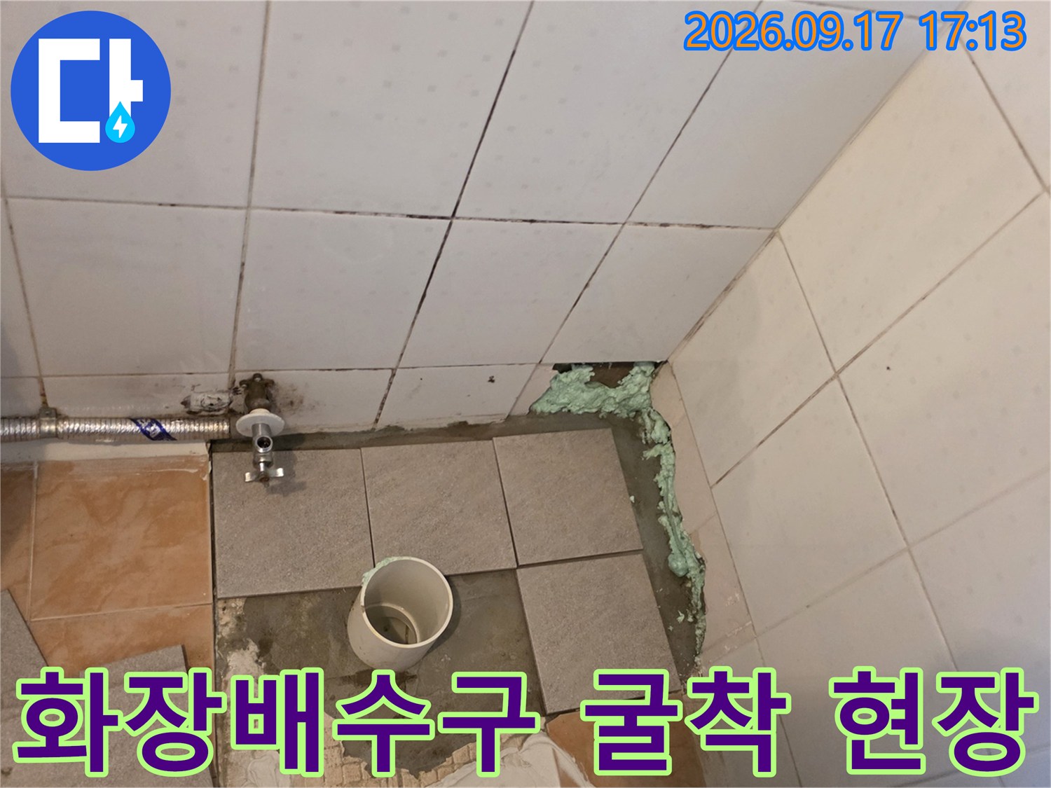 타일을 제거한 화장실 바닥의 배수 파이프와 벽면 배관 연결 부위입니다.