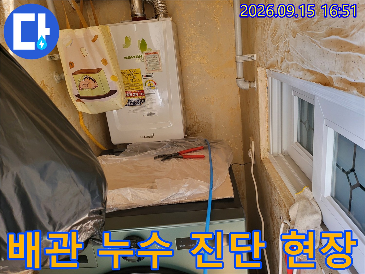 보일러실 배관에 연결된 노란색 호스와 점검 장비의 모습입니다.