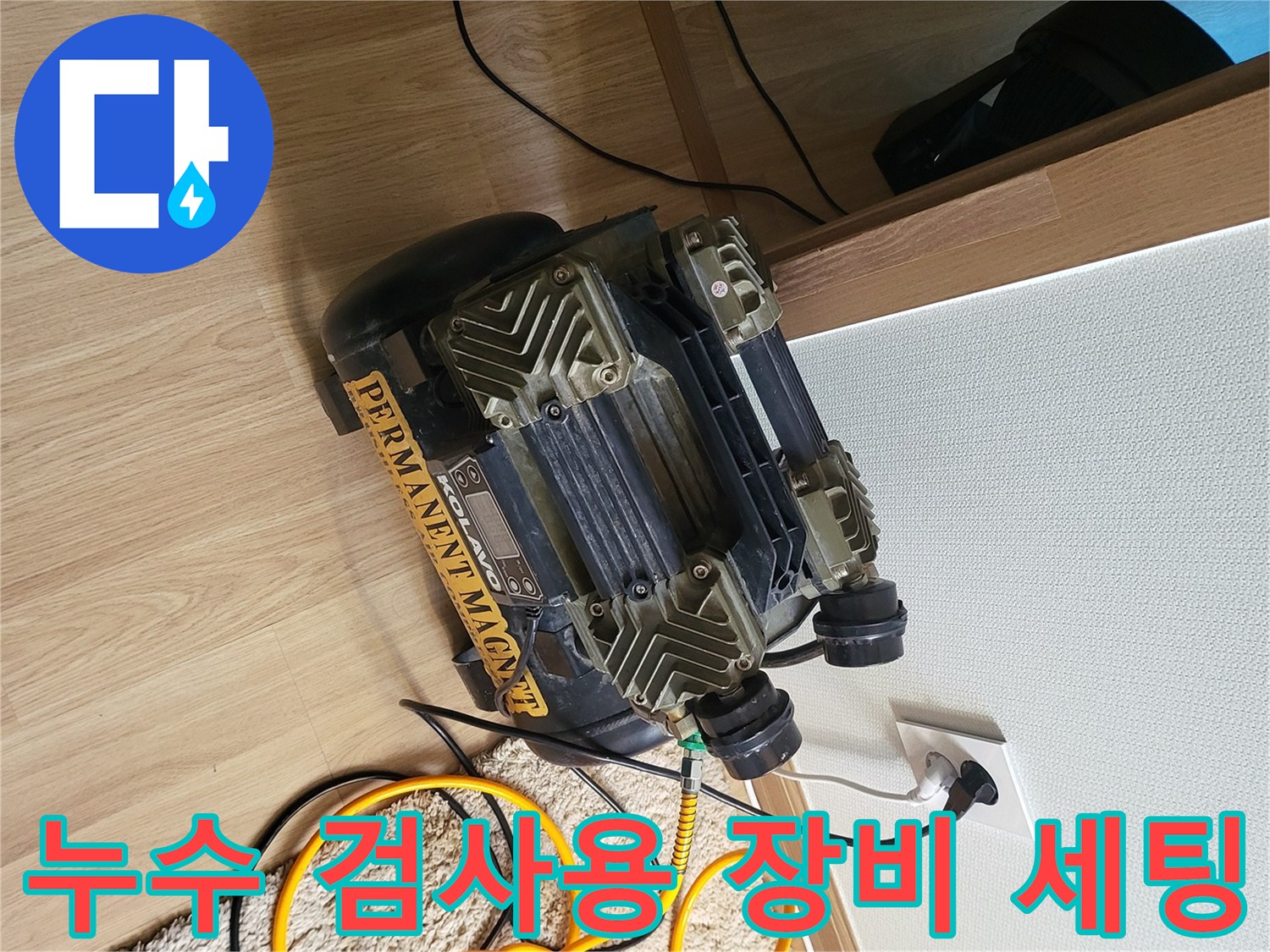 콘센트에 꽂힌 컴프레셔와 바닥에 펼쳐진 노란색 가스 탐지 호스