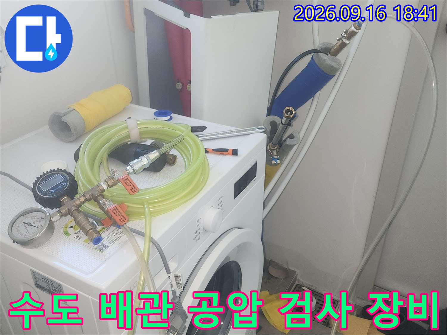 파란색 필터와 압력계가 연결된 배관 검사 장치입니다.
