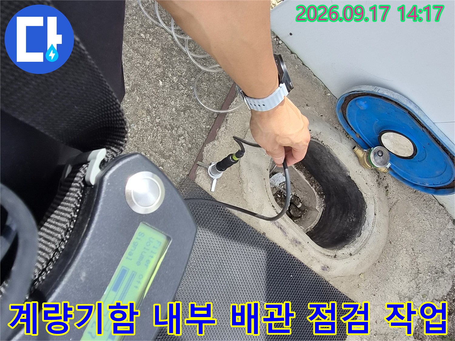 파란색-계량기 덮개를 열고 배관 연결 부위를 탐지기로 세밀하게 검사하고 있습니다.