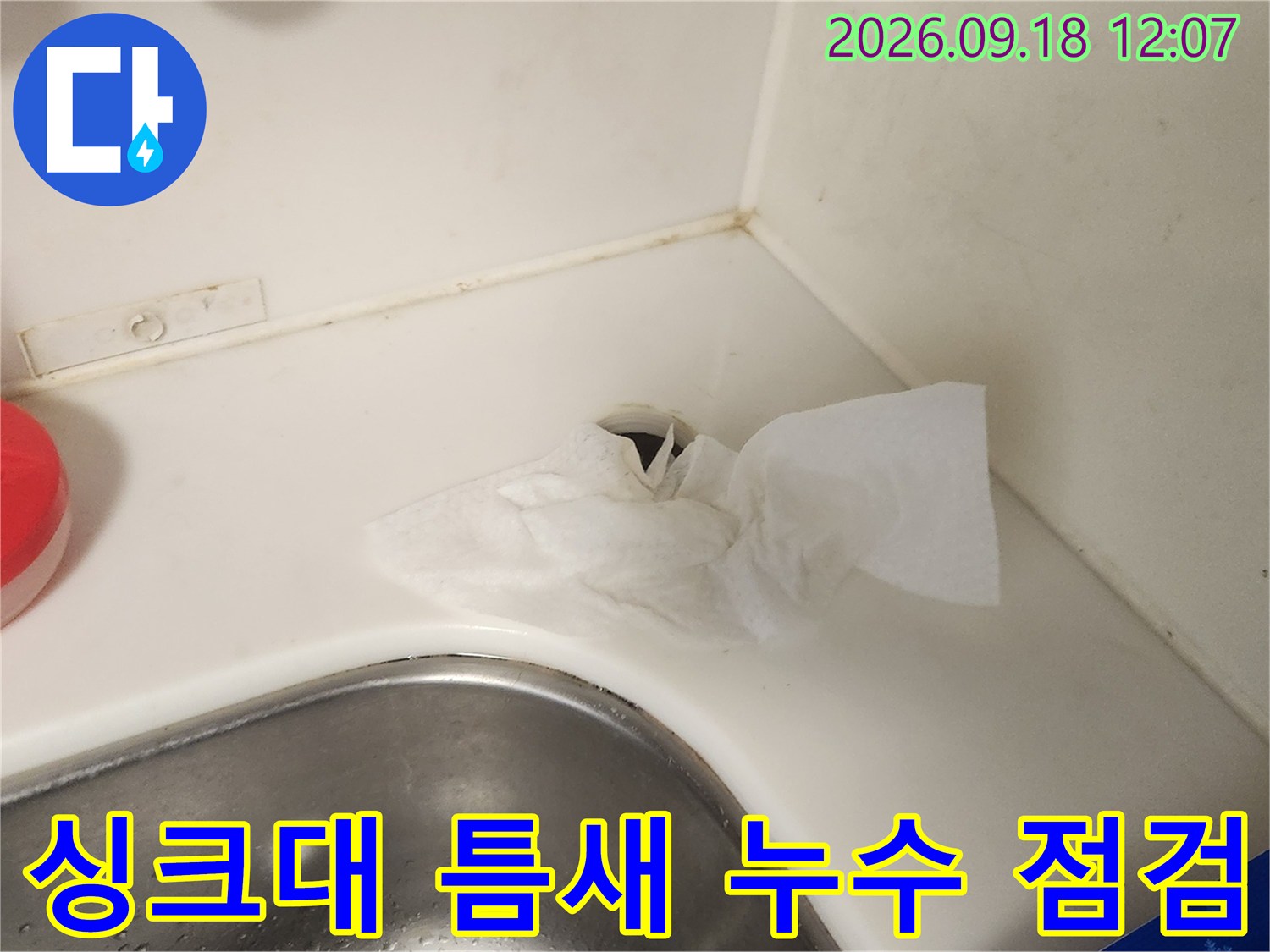 싱크대 상판과 수전 사이의 물기 및 오염 상태를 확인하고 있습니다.